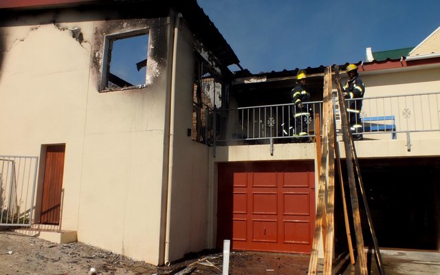 Gansbaai Brandweermanne besig om van die dakplanke te verwyder.